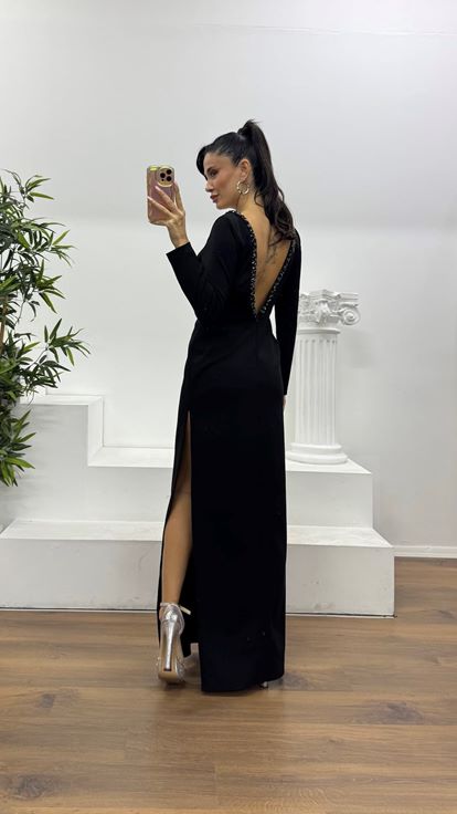 Schwarzes, tief eingefasstes, mit Steinen verziertes Abendkleid in besonderem Design